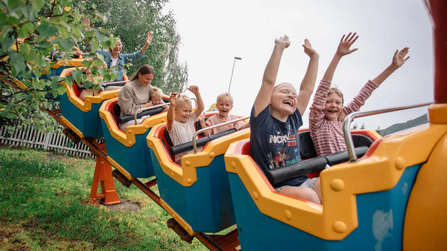 Fornøyde barn i attraksjonen Berg og dalbane