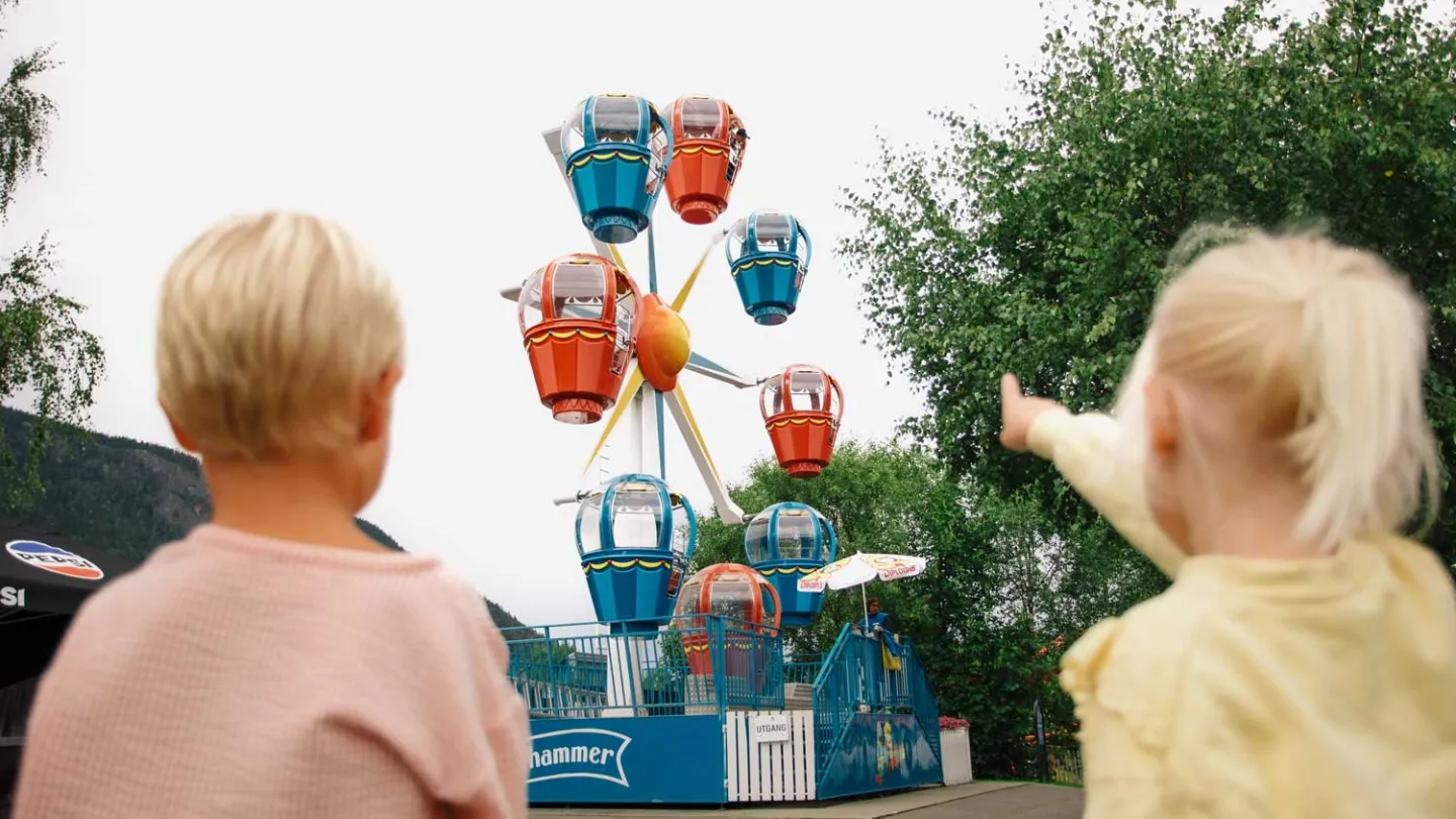 To barn står å ser på attraksjonen pariserhjulet